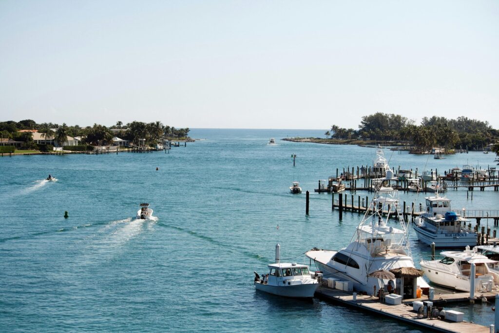 A picturesque scene of yachts and boats docked at Jupiter Inlet, FL, under a clear sky.